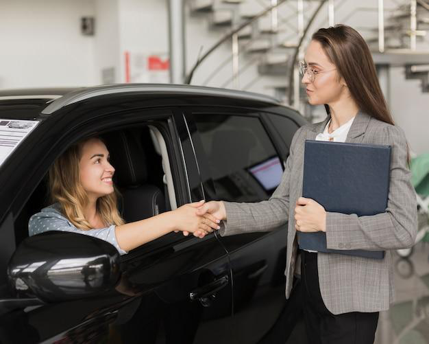 A person shaking hands with an agent after car registration