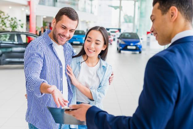 An auto tag expert explaining the title transfer process to clients