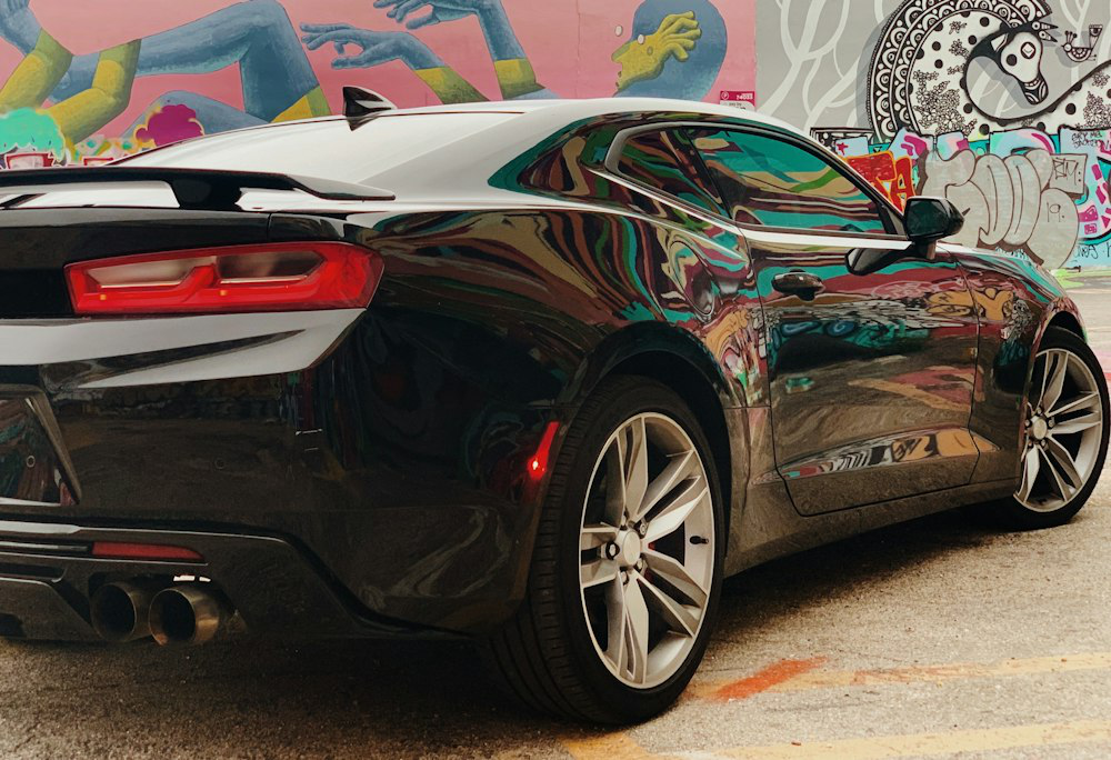 A car standing next to a wall with graffiti art