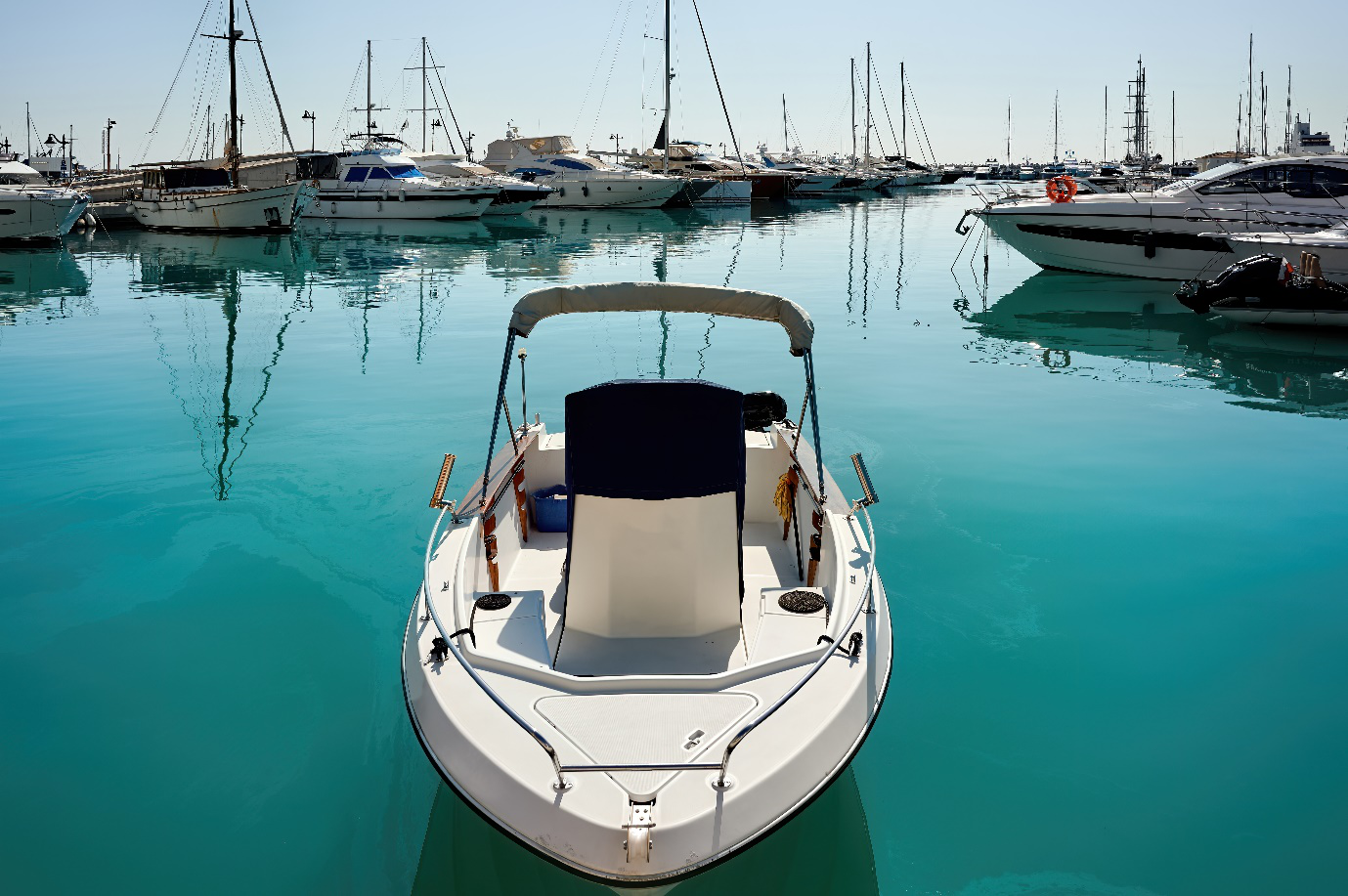 A boat overlooking several others on turquoise blue water