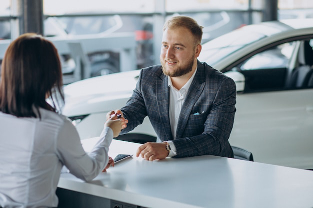 A person shaking hands with an auto tag agency professional