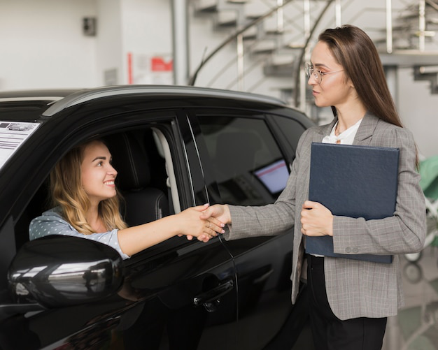 A person shaking hands with an auto tag agency professional.