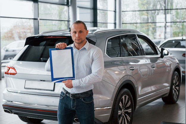 An auto tag agency professional holding a blank paper