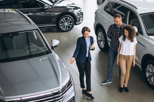 A sales person showing a couple a car
