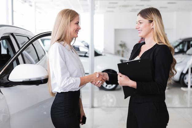 A vehicle title transfer expert shaking hands with a client