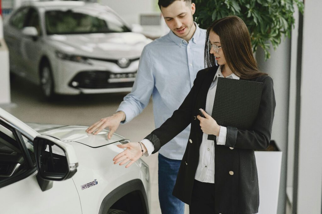 An agent showing a car to a customer
