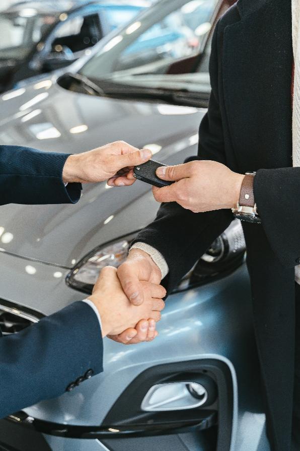 A person handing over car keys to another