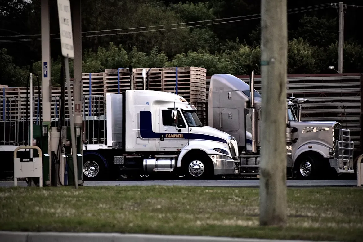 Trucks next to a wooden fence